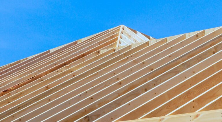 Charpente en bois en cours de construction sous un ciel bleu